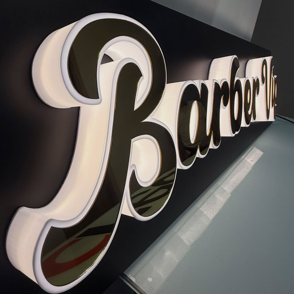 3D script channel letters with glowing acrylic side borders mounted on black composite tray in Acacia Mall, Kisementi, Kampala, Uganda.