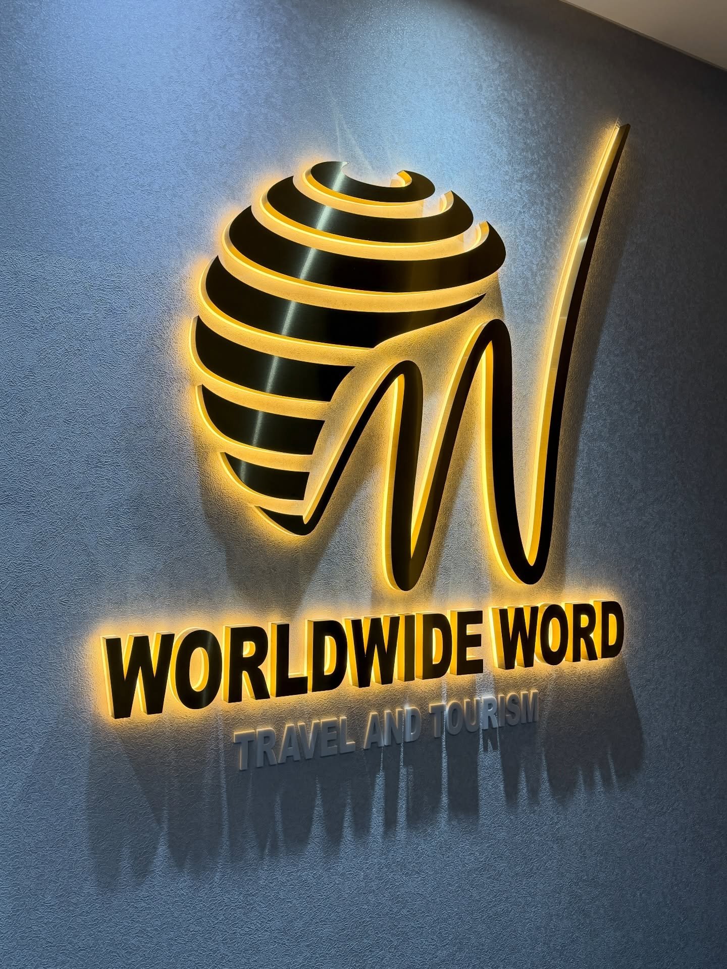 3D brushed gold halo-lit logo and channel letters installed on textured corporate wall in Kololo, Kampala, Uganda.