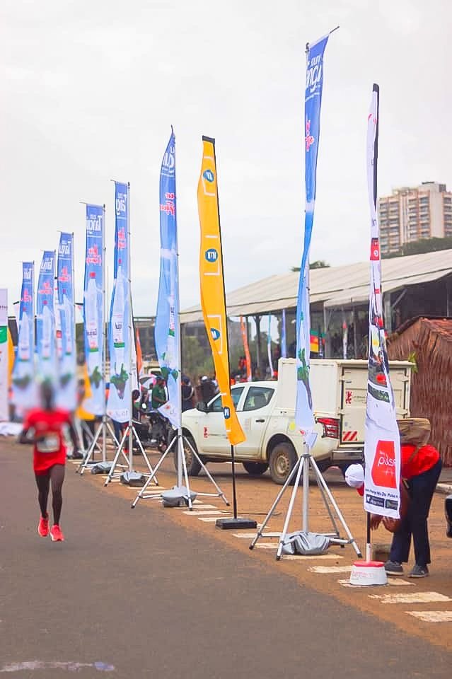 Integrated corporate sponsorship event signage suite featuring teardrop flags, retractable roll-up banners, and vertical feather flags in Kyambogo, Kampala, Uganda—crafted by the biggest industrial ad